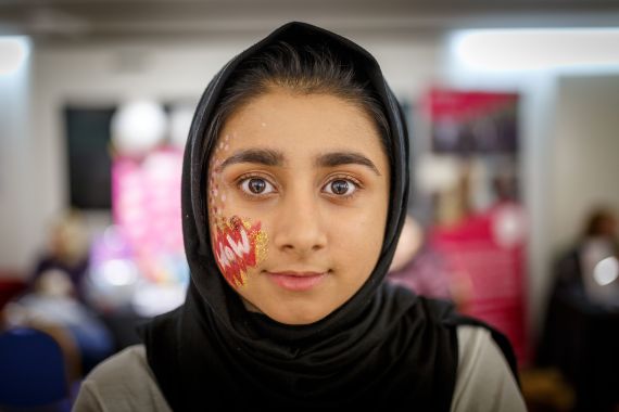 A girl with WOW face paint on her cheek